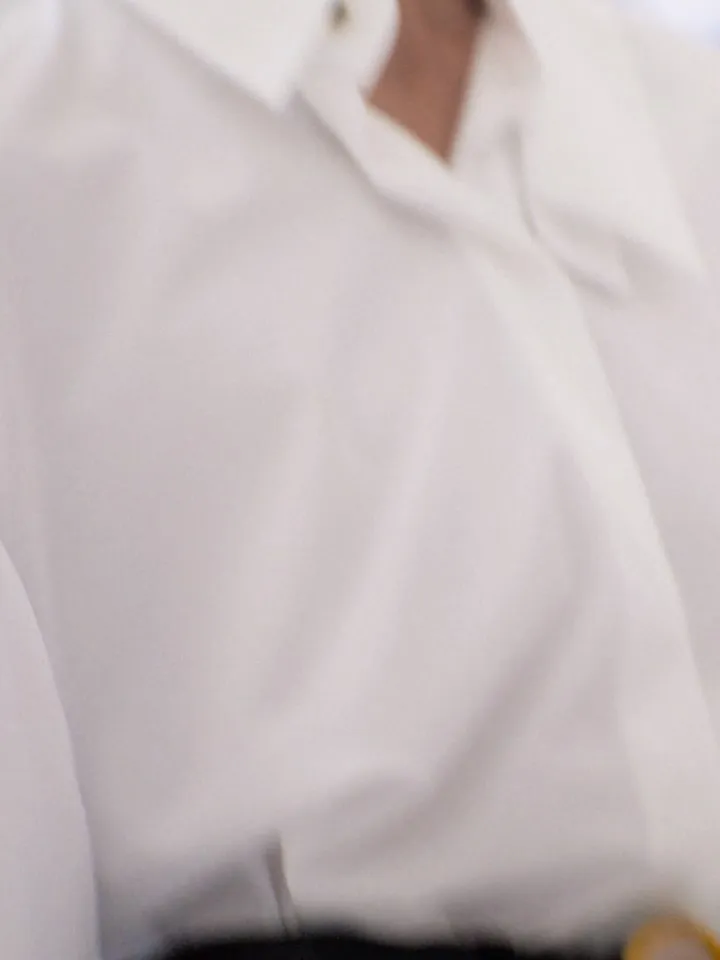 Model wearing fluid trousers in pale grey with softly draping silhouette
