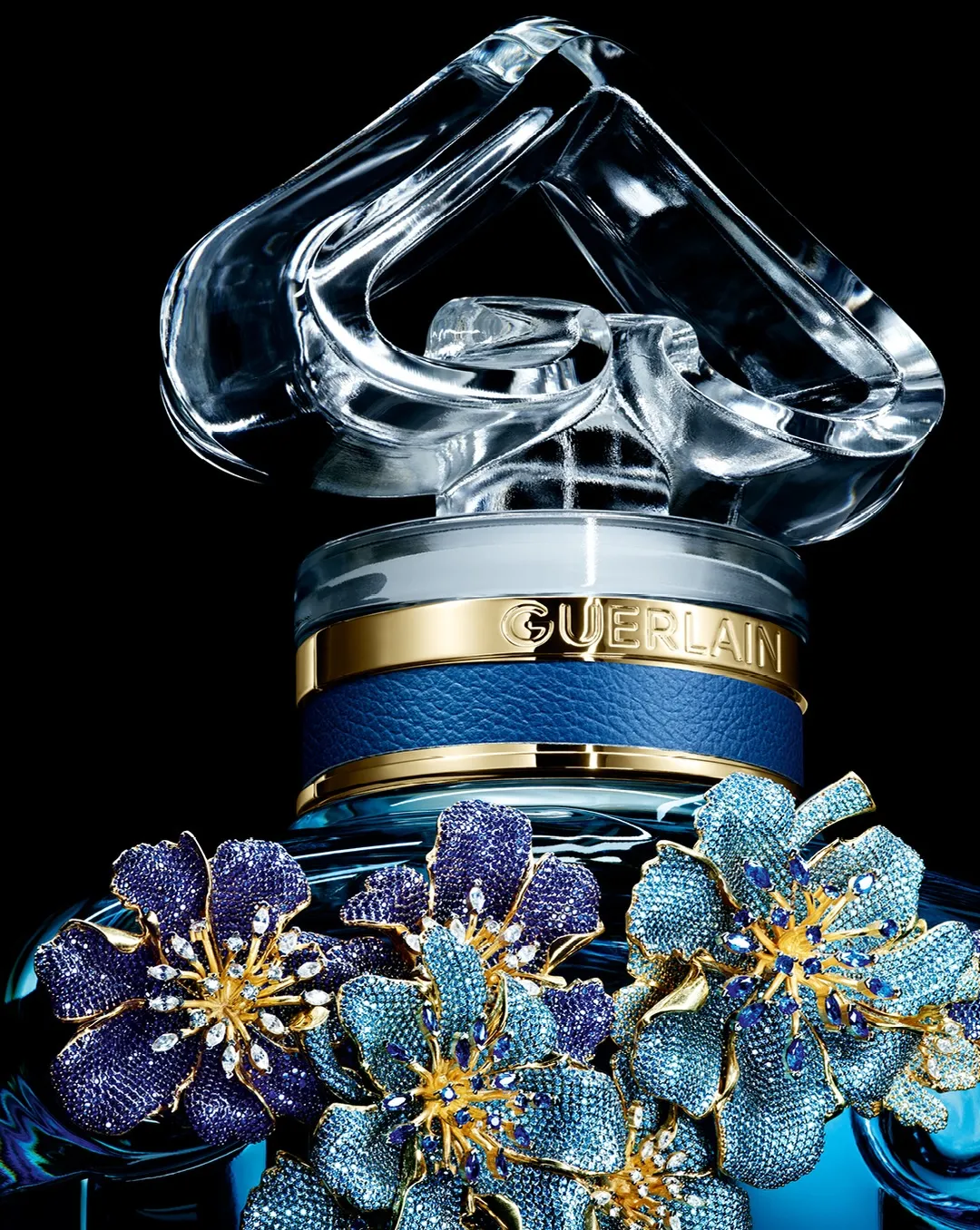 Close detail of hand-set gemstones in shades of blue creating luminous patterns across the floral composition