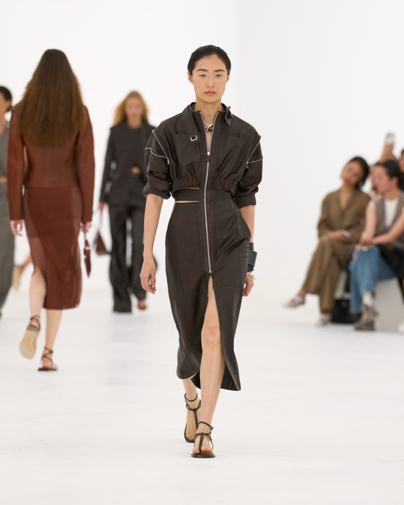 Elongated silhouette in soft butter tone featuring tapered sleeves and graceful proportions