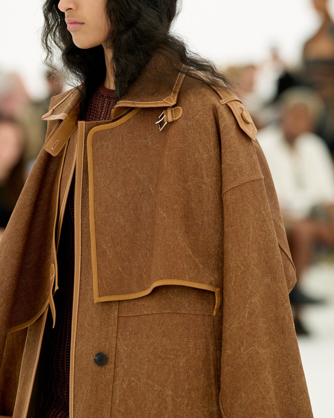 Runway presentation of flowing evening piece with lifted hem detail