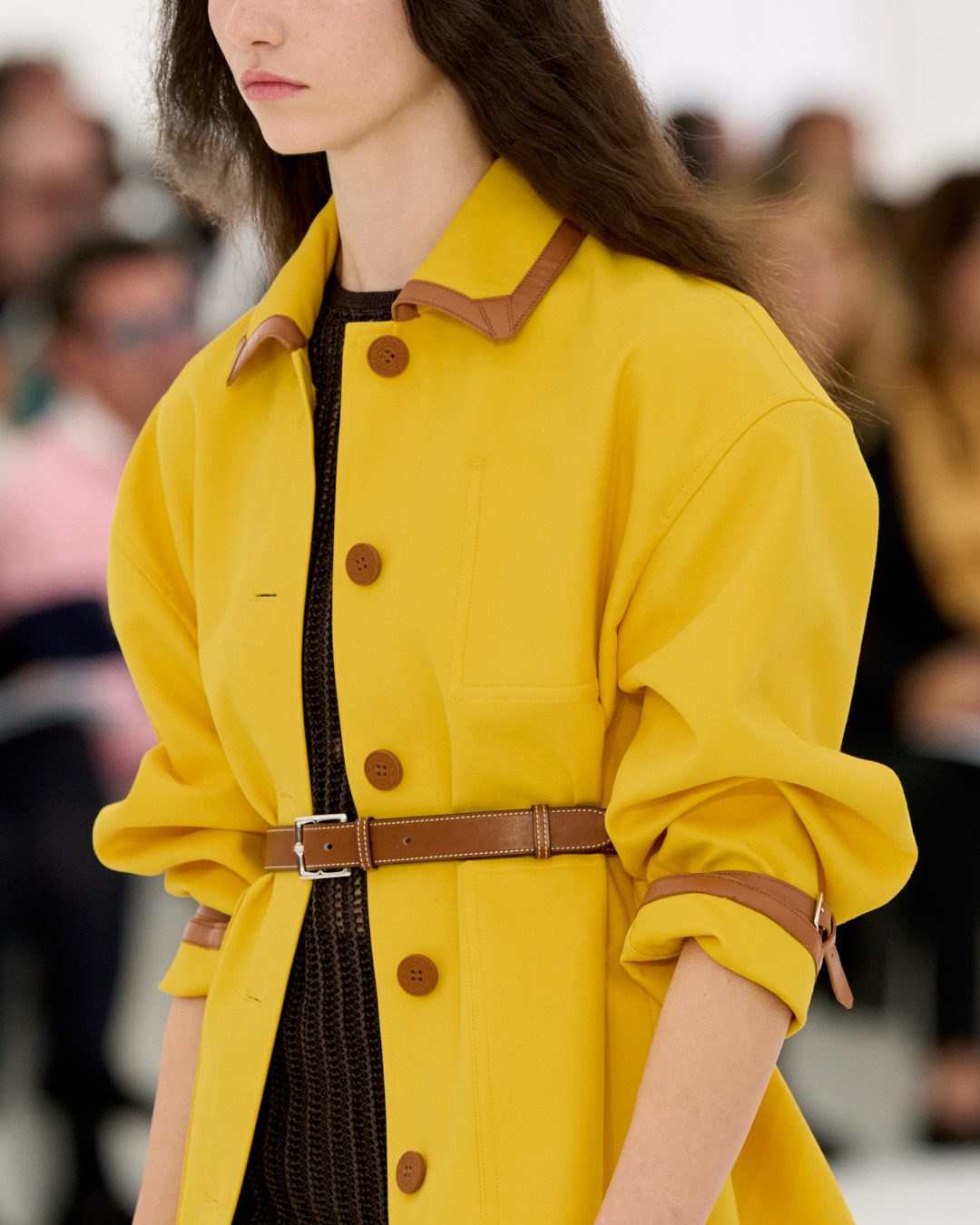 Model wearing sleeveless shell with sculptural proportions