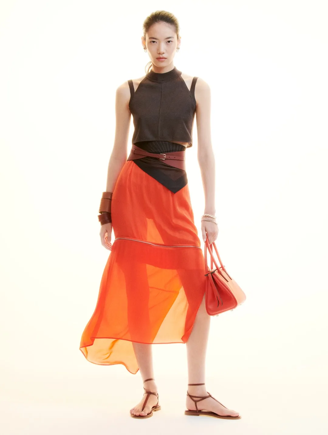 Full-length view of model in pale cream dress with geometric vent details and refined tailoring