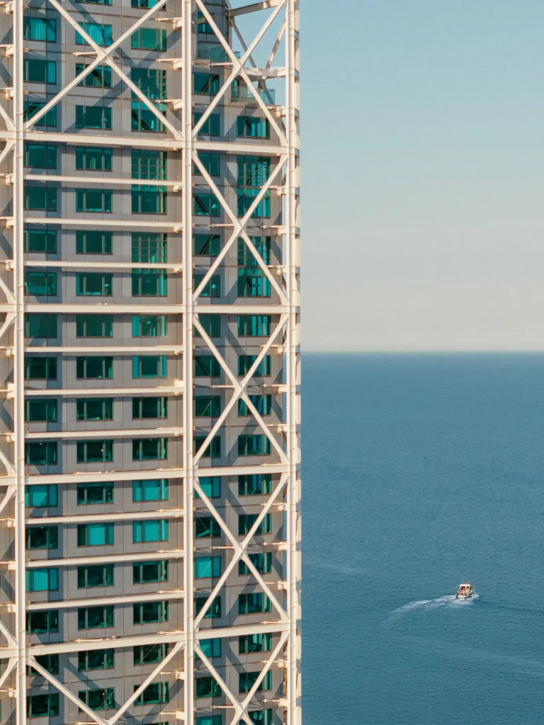 Hotel Arts Barcelona exterior showcasing its distinctive architectural silhouette against the Barcelona skyline, Mediterranean Sea visible in the background