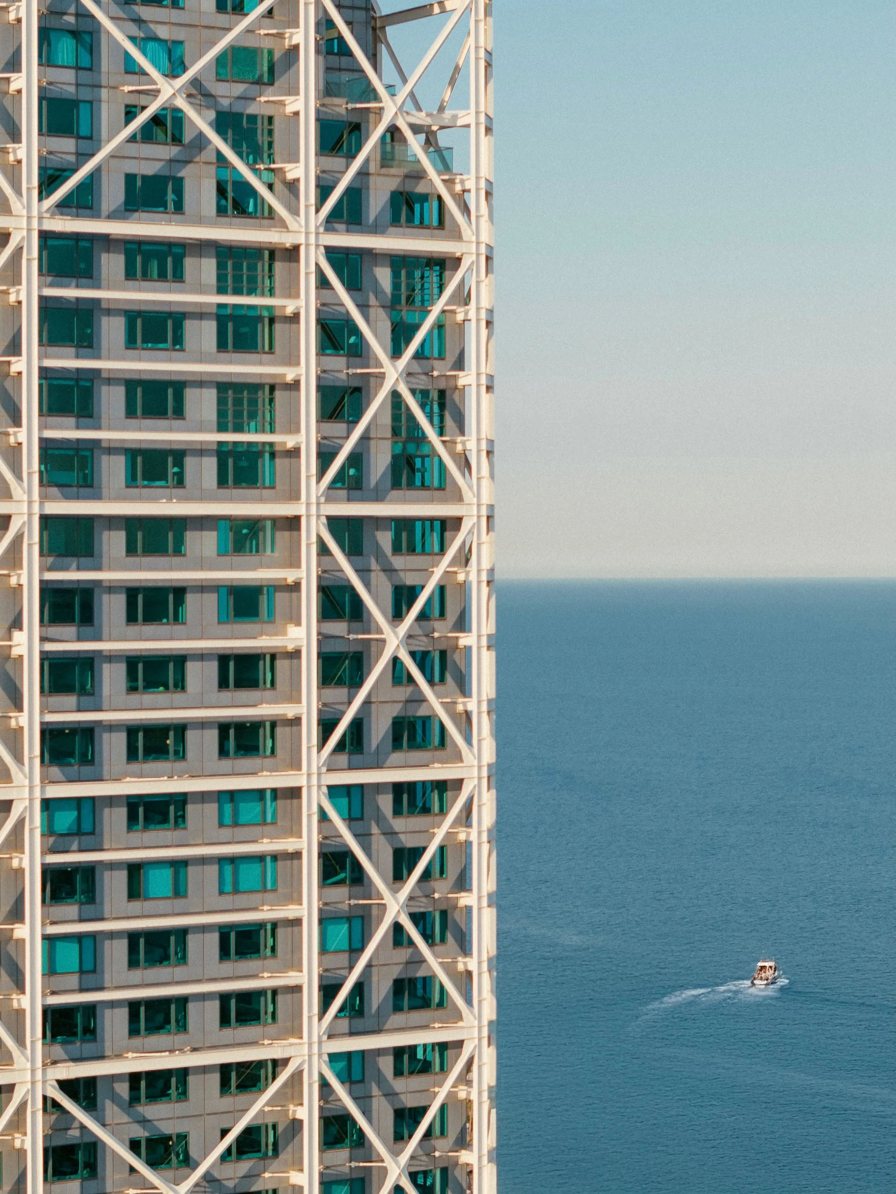 Hotel Arts Barcelona exterior showcasing its distinctive architectural silhouette against the Barcelona skyline, Mediterranean Sea visible in the background