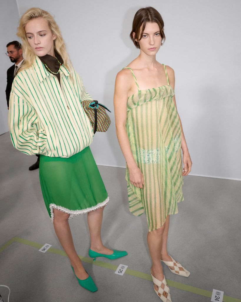 A full-length view of a model in a glass bead dress, showing how the garment moves and creates shadows and luminescence with body movement