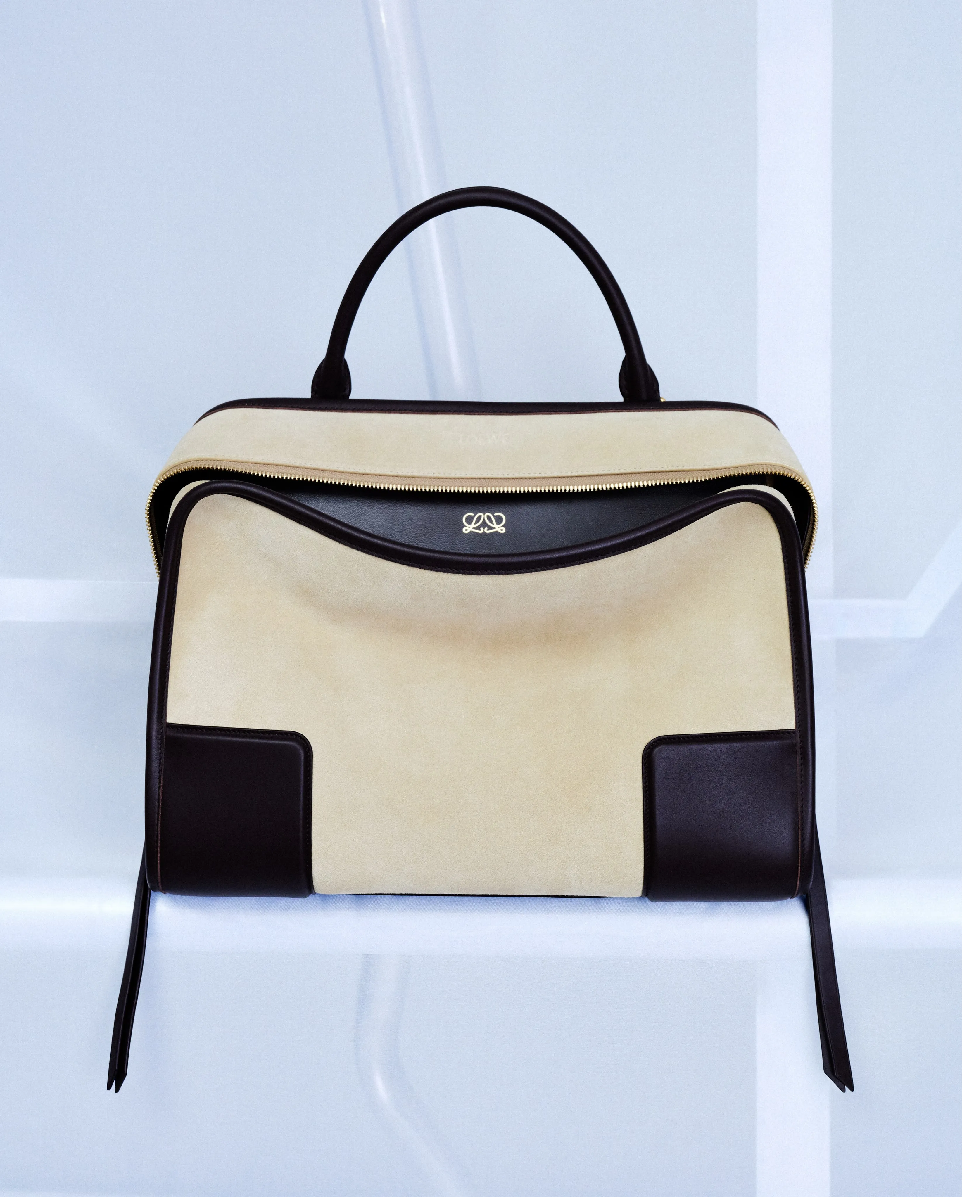 Loewe Amazona 180 leather bag in rich cognac tone, displayed against a neutral backdrop, showcasing the iconic trapezoidal silhouette and structured handle