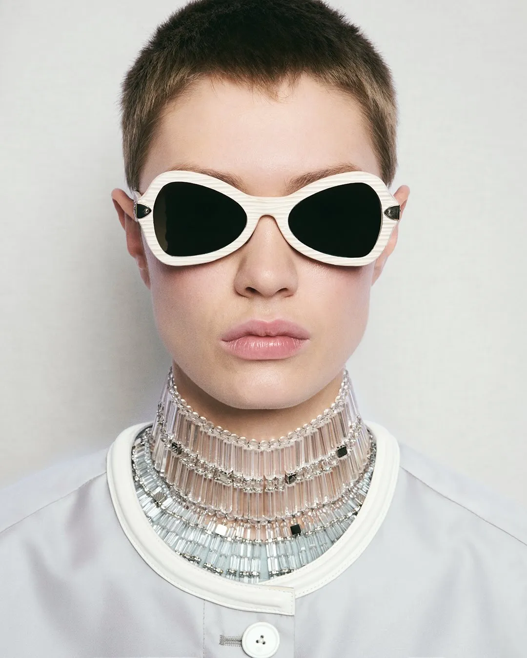 Model at Louis Vuitton Spring-Summer 2027 show wearing luminous makeup with glowing skin and curved ivory frame accessories