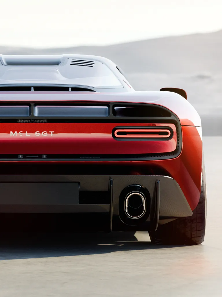 Full view of the McLaren 6GT in high-metallic red against neutral background
