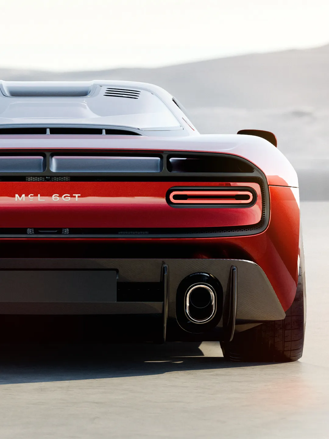 Full view of the McLaren 6GT in high-metallic red against neutral background