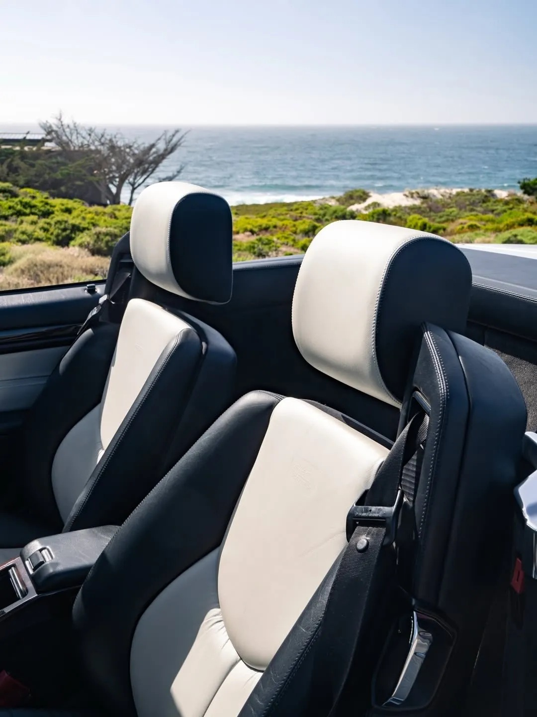 The iconic SL 500 positioned along a sun-drenched coastline with sea views in the distance