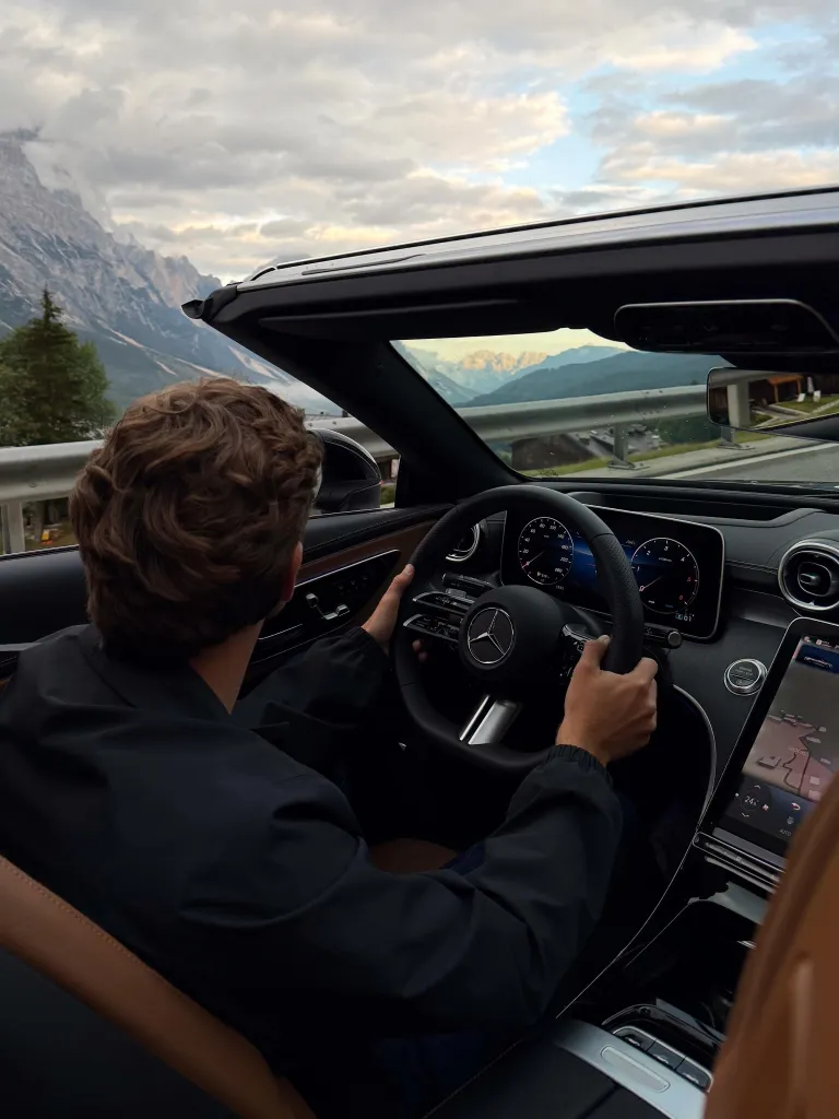 Aerial view of the convertible Mercedes-Benz navigating a scenic mountain pass