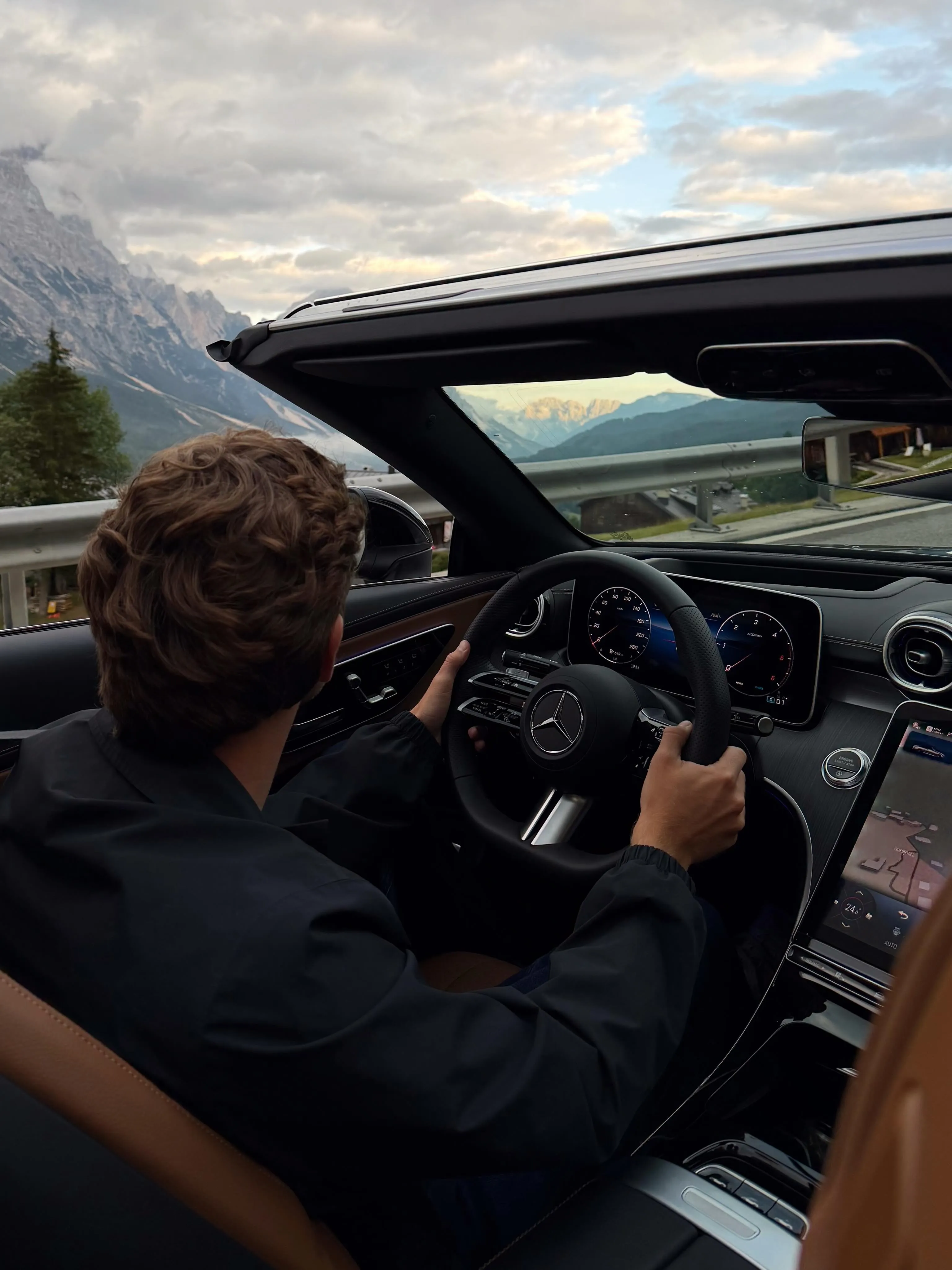 Aerial view of the convertible Mercedes-Benz navigating a scenic mountain pass