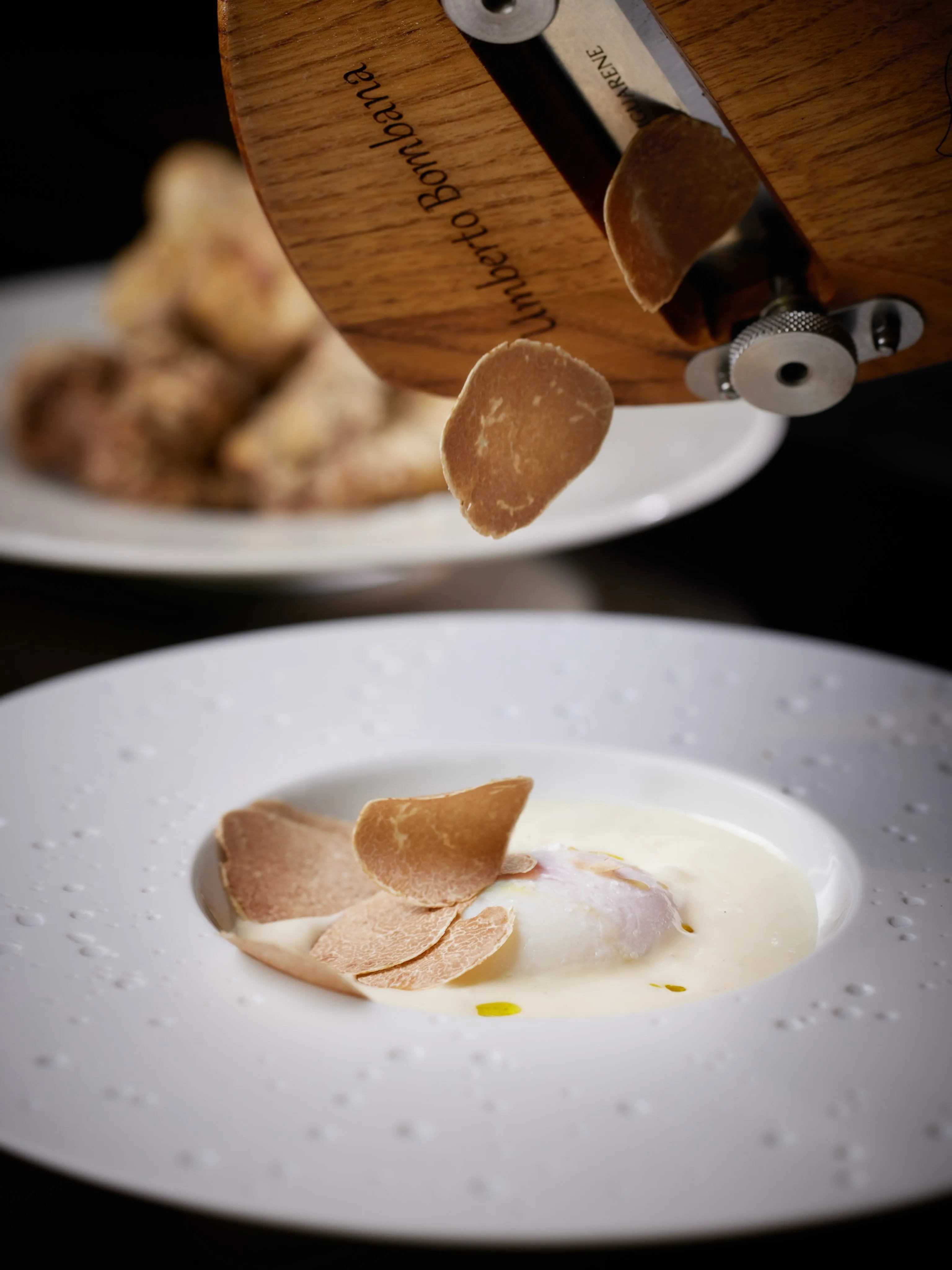 Otto e Mezzo Bombana signature dish featuring Alba white truffles, artfully presented with seasonal ingredients