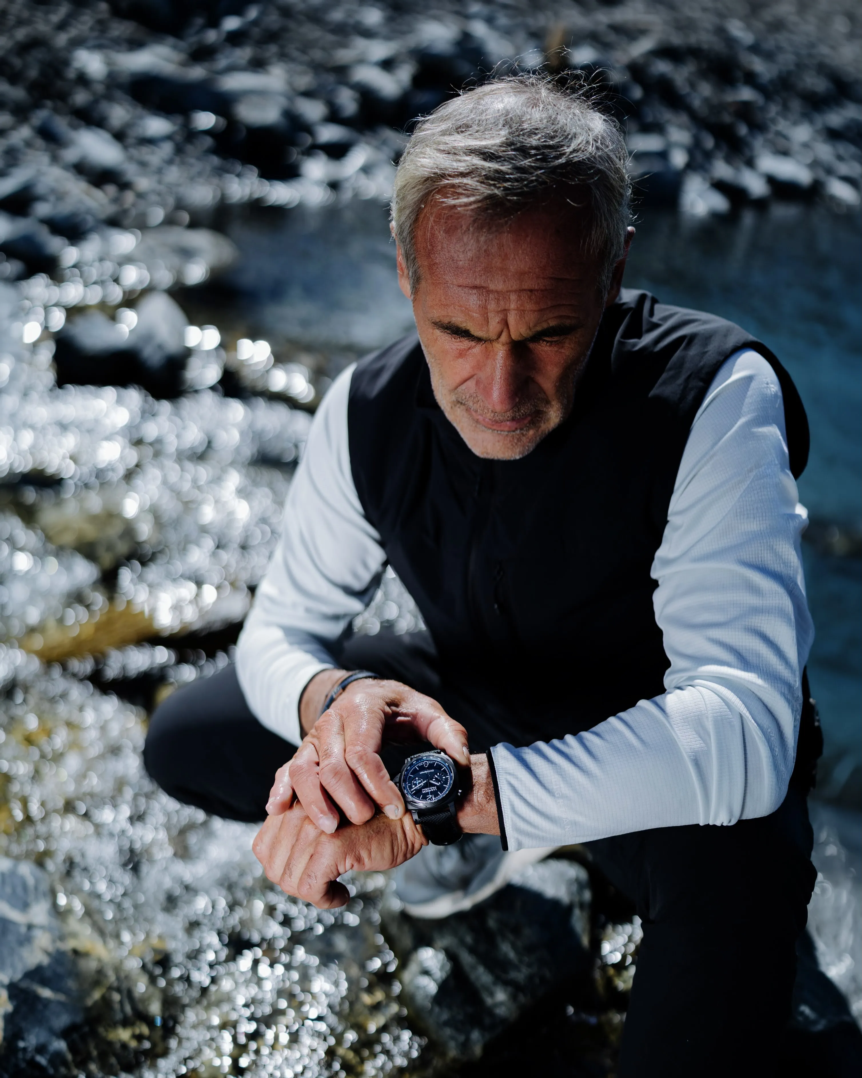 Panerai Luminor Chrono Carbotech PAM01219 chronograph watch with matte black dial and electric blue accents, displayed on wrist at altitude