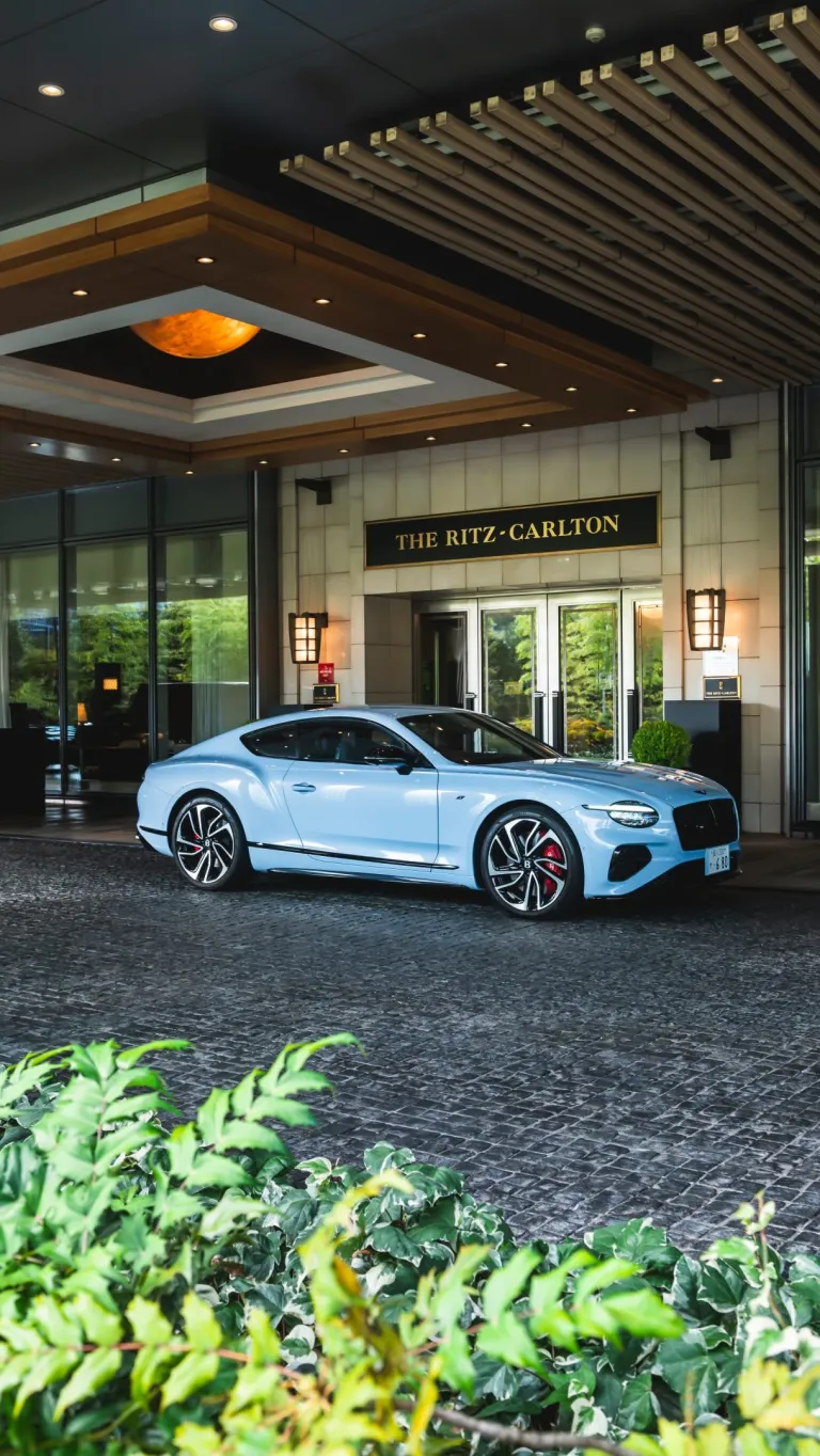A Bentley motorcar winds through misty mountain roads leading from Tokyo towards Nikko's serene alpine landscape