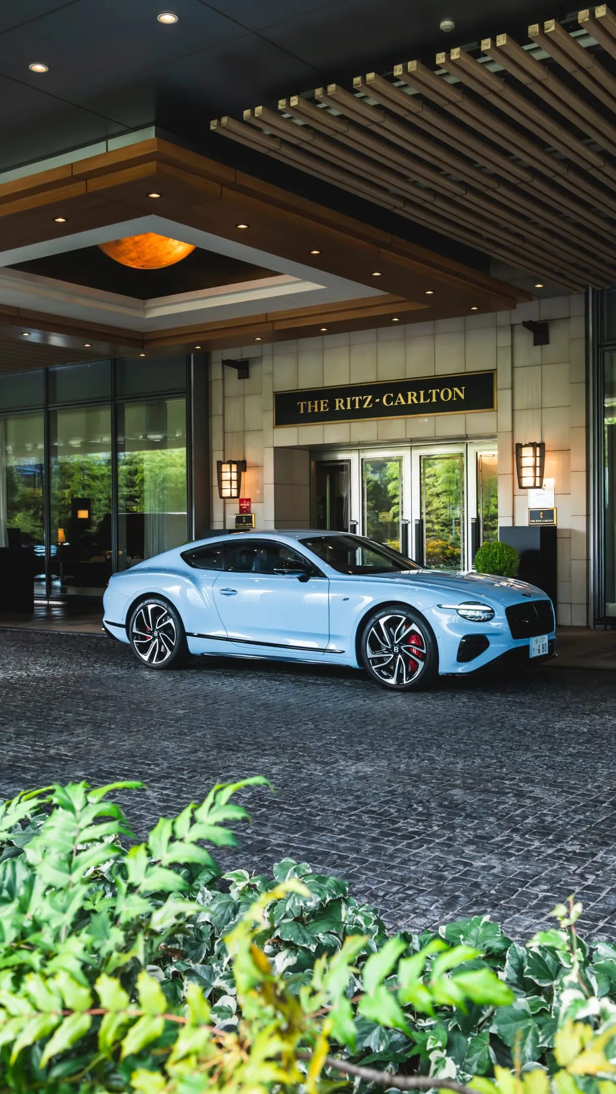 A Bentley motorcar winds through misty mountain roads leading from Tokyo towards Nikko's serene alpine landscape