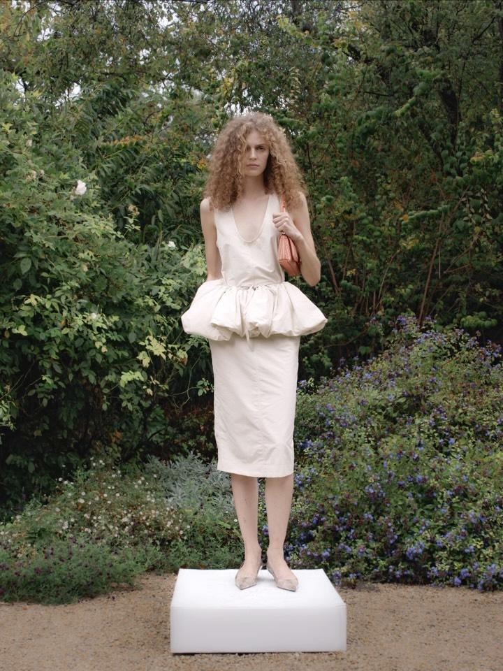 The Ryder clutch in handwoven vegan leather alternative, crafted in Italy and styled alongside the peplum dress