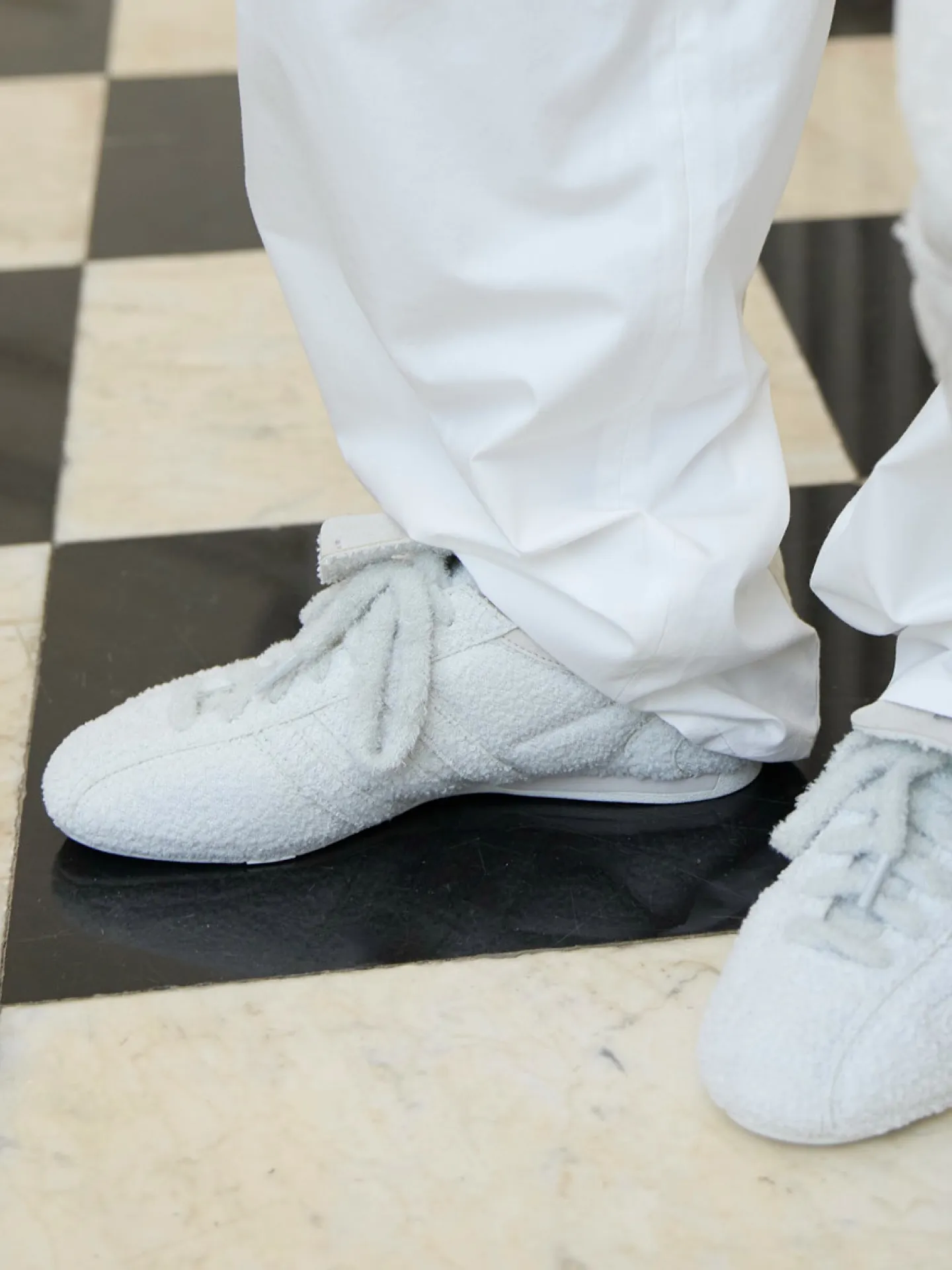 Artisanal finishing details captured backstage illustrating McCartney design philosophy