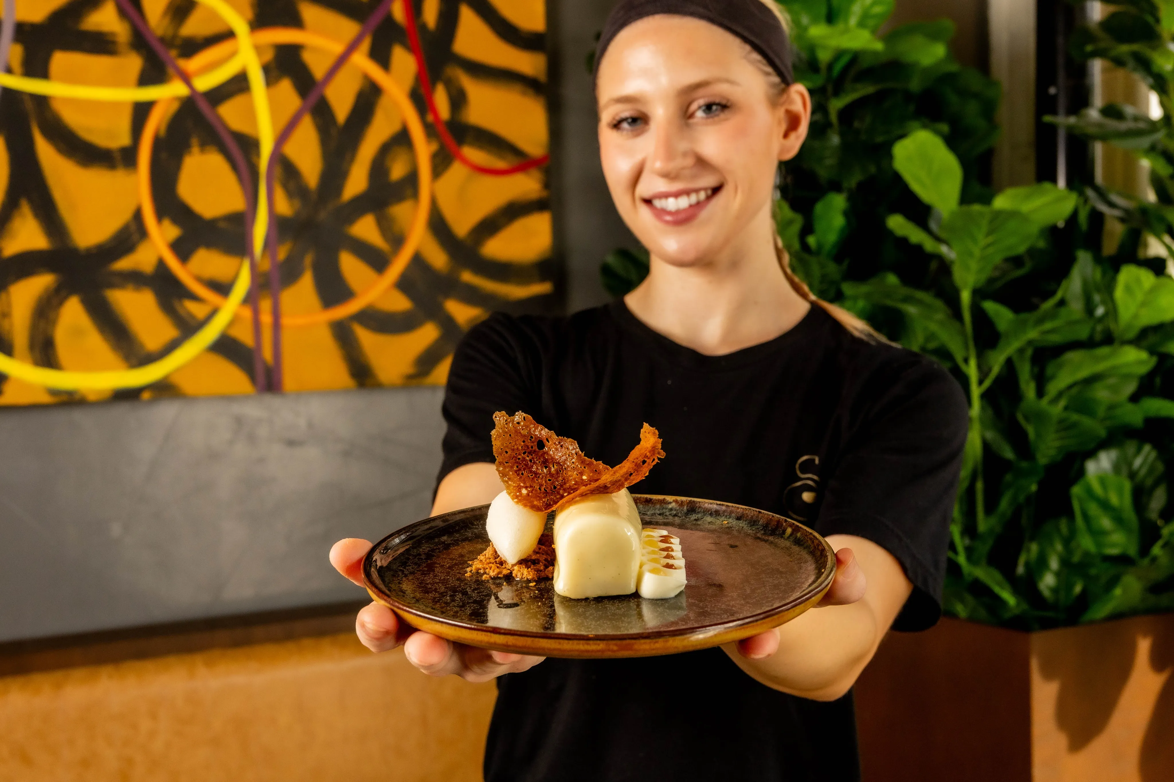 Elegant plating of Stubborn Seed's Spiced Pear and Cream dessert with allspice madeleine and praline chocolate components
