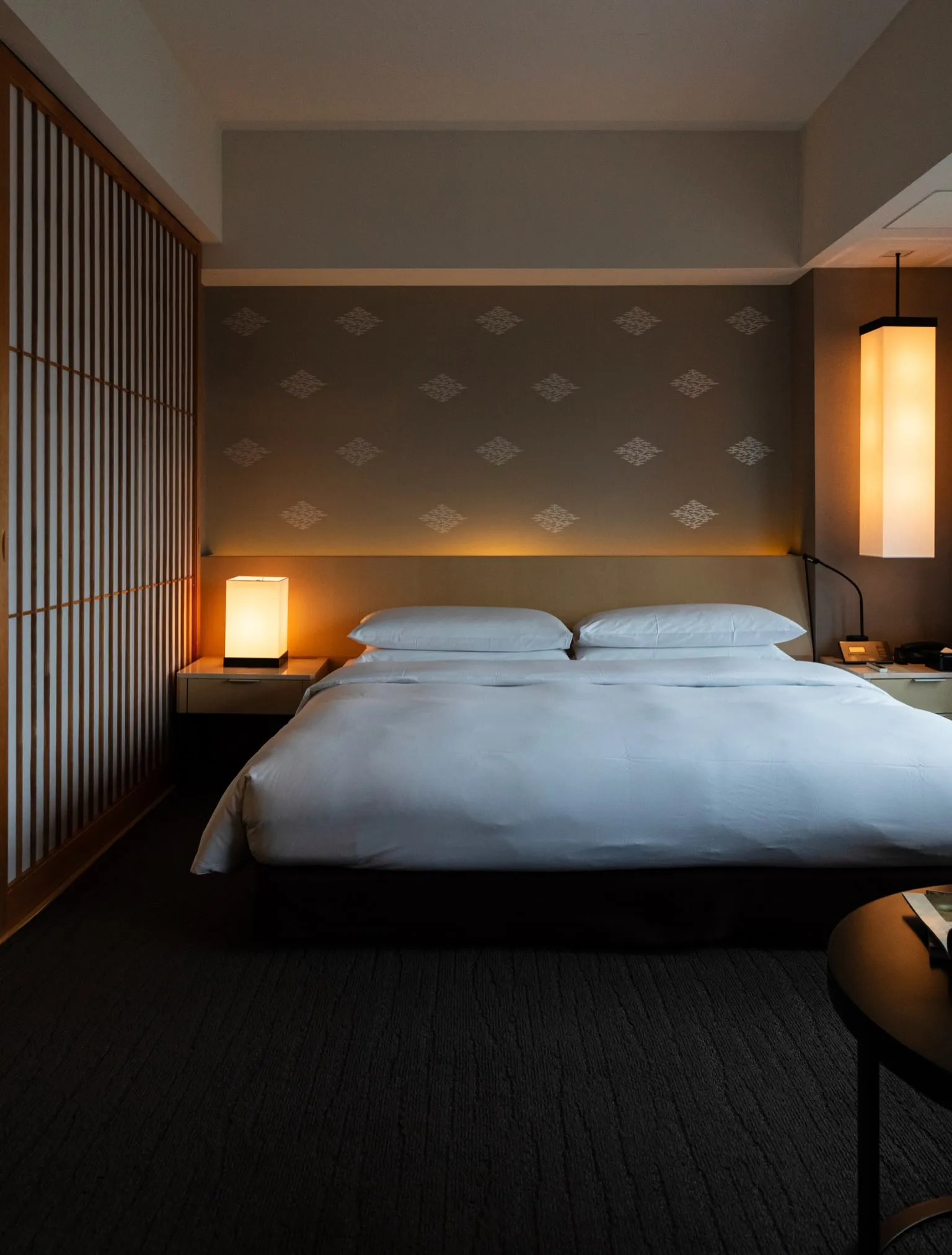 The Capitol Hotel Tokyu guest room interior showcasing warm ambient lighting, natural wood textures and serene Japanese design details