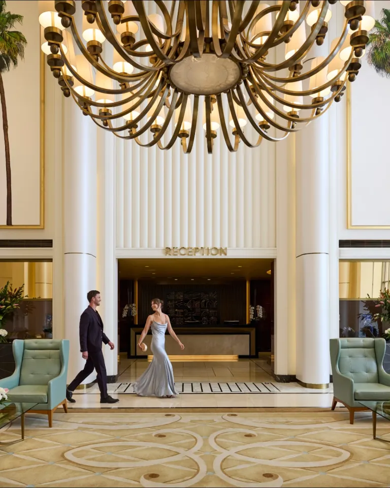 The grand entrance of Waldorf Astoria Beverly Hills on Sunset Boulevard, illuminated with sophisticated architectural lighting