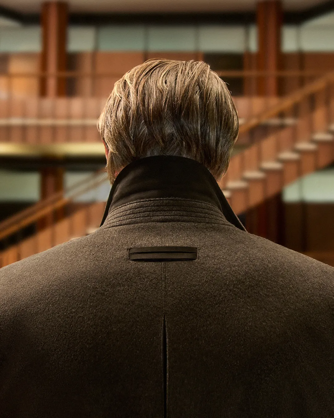 Mads Mikkelsen wearing the Falcon jacket in charcoal grey wool at the modernist Olivetti Headquarters
